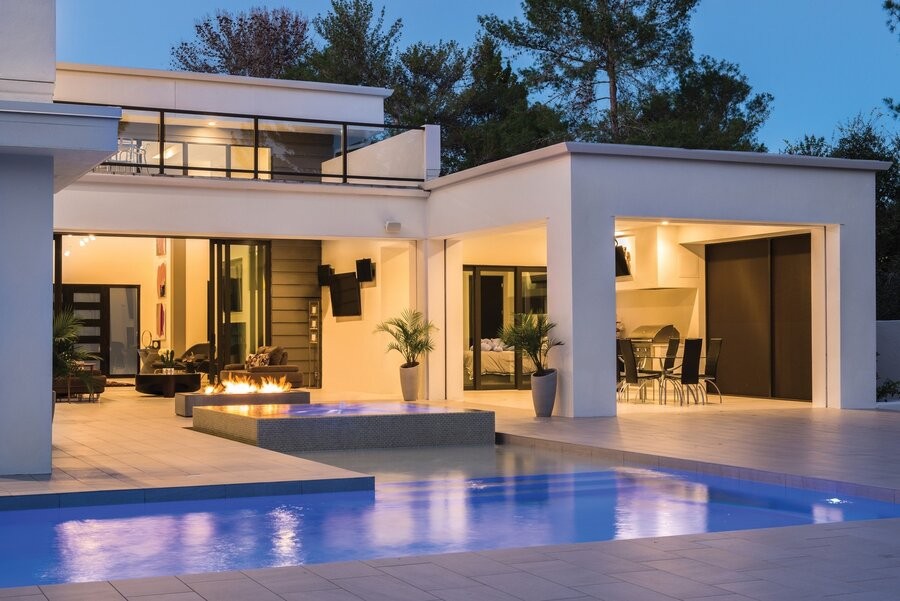 An outdoor living space featuring outdoor shades and a pool.
