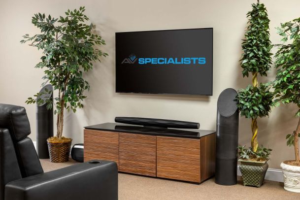 Living room setup with TV, soundbar, and tall black speakers